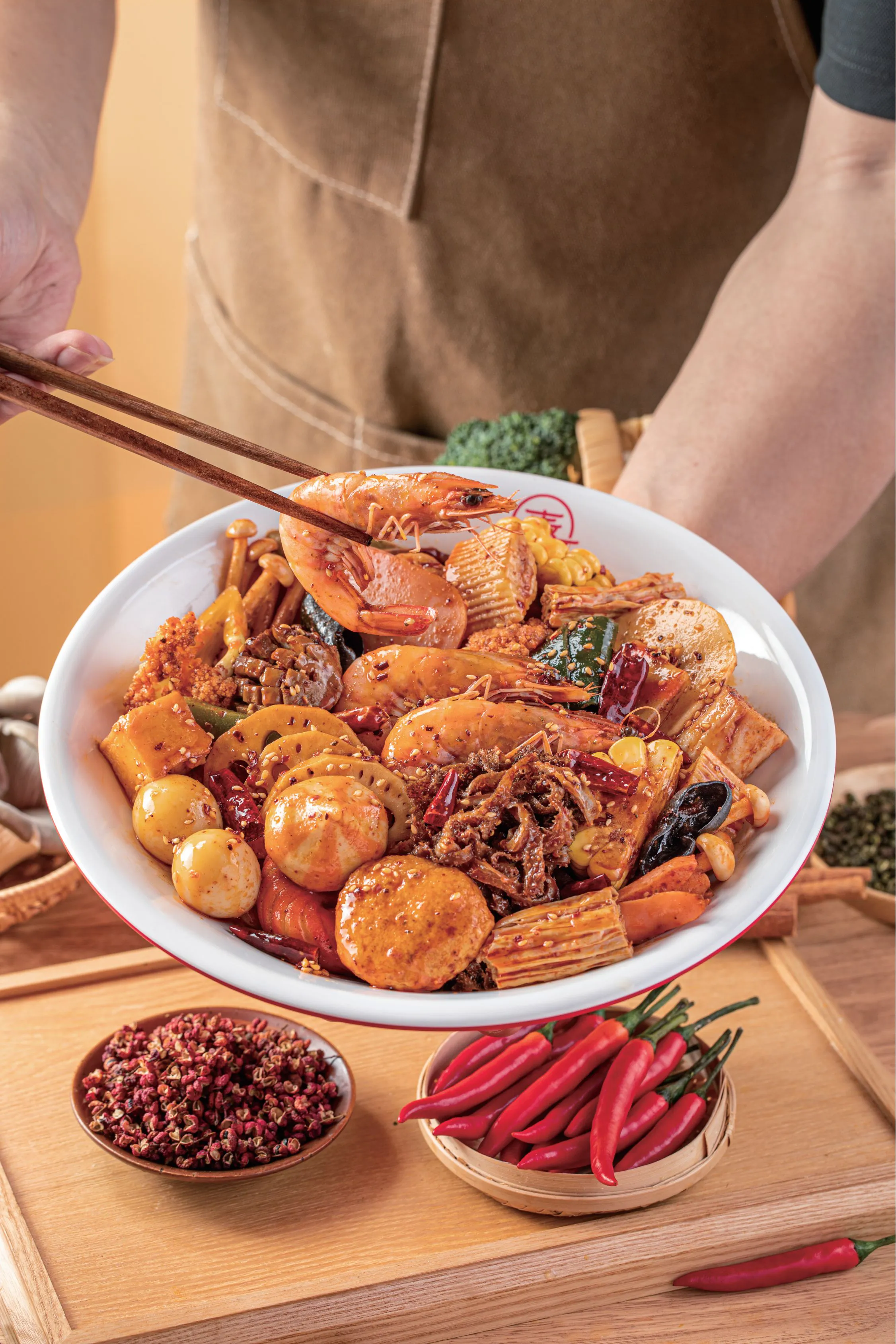 Spicy mala stir-fry with seafood held by chopsticks at Spice House, a Chinese Restaurant in Plano